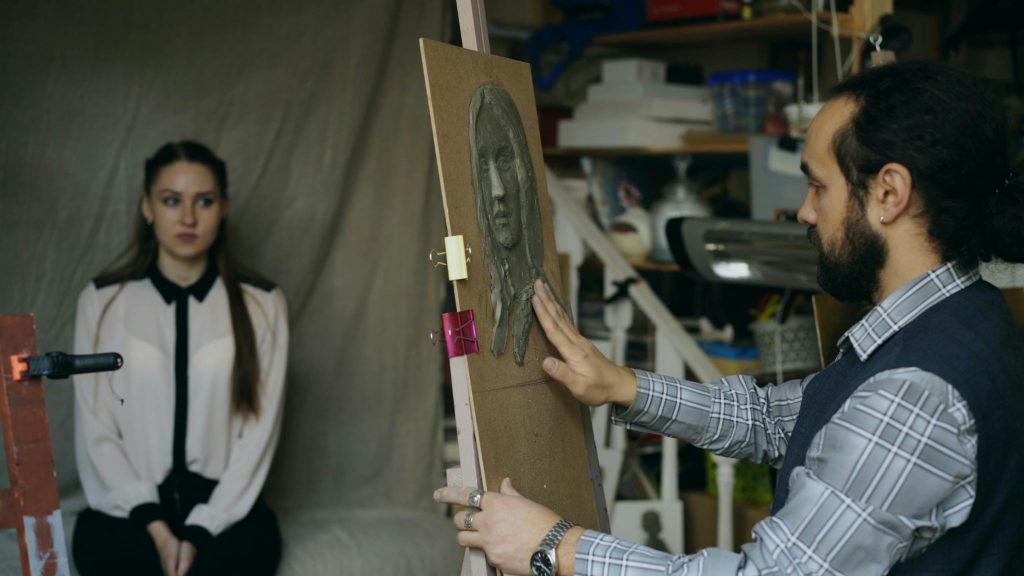 Artist sculptând un portret feminin în atelier – imagine simbolică pentru politica de confidențialitate și protecția datelor personale GDPR Politica de confidențialitate (GDPR)